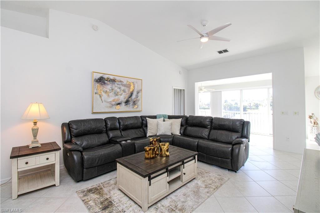 Tiled living room featuring ceiling fan and lofted ceiling