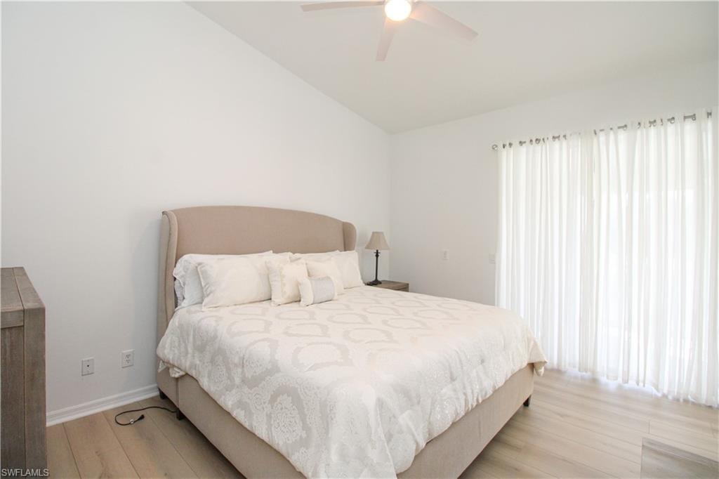 Bedroom featuring vaulted ceiling, light hardwood / wood-style flooring, and ceiling fan