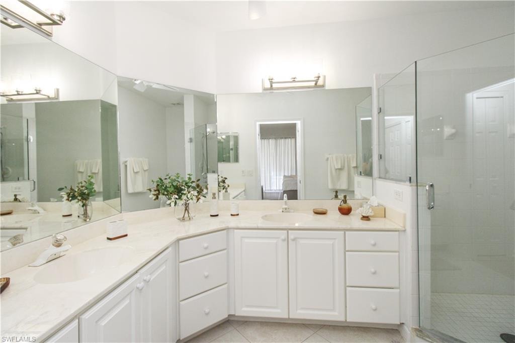 Bathroom featuring vanity, tile patterned floors, and an enclosed shower