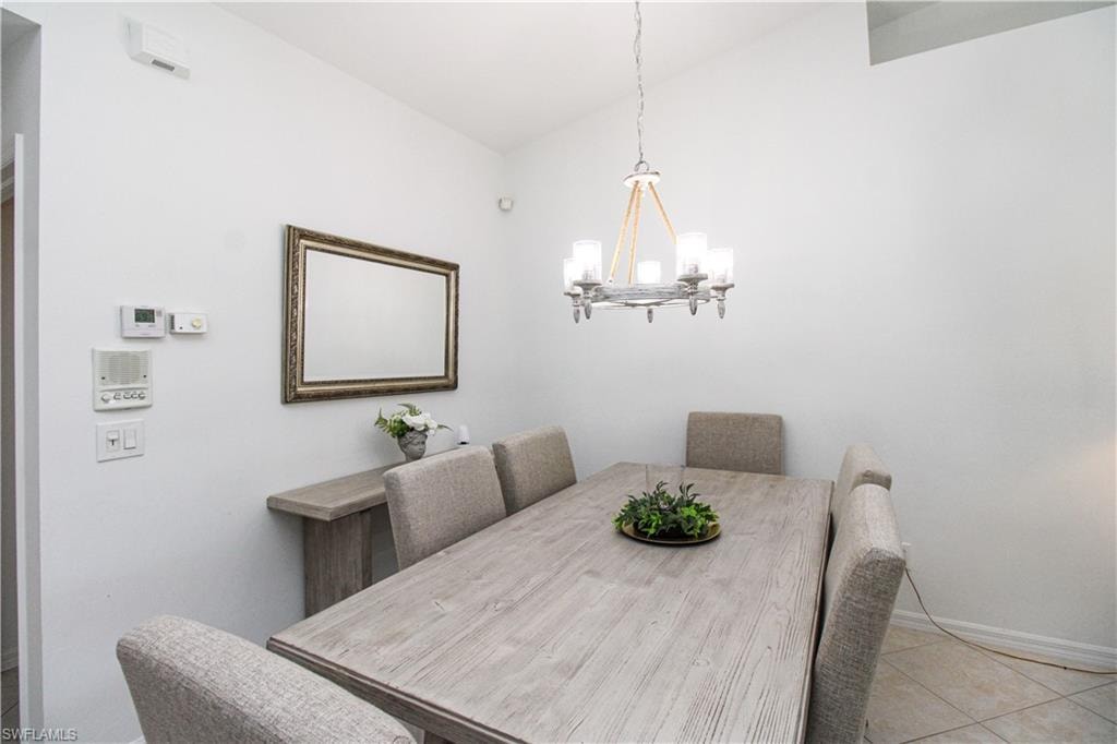 Tiled dining space featuring a notable chandelier