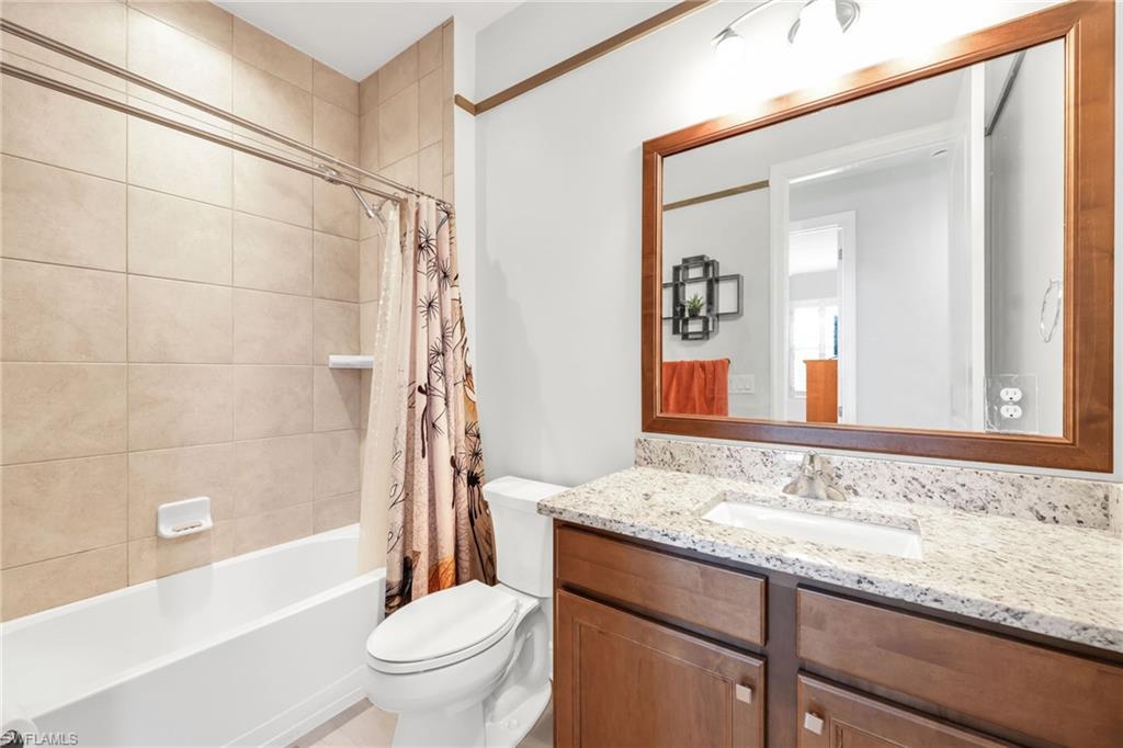 Bathroom with shower / tub combo with curtain and vanity