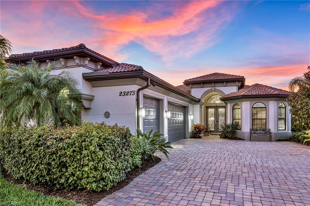 Mediterranean / spanish-style house with french doors, stucco siding, a garage, decorative driveway, and a tiled roof