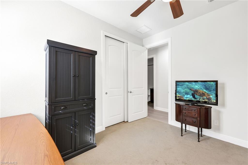 Unfurnished bedroom featuring light colored carpet, a closet, and ceiling fan