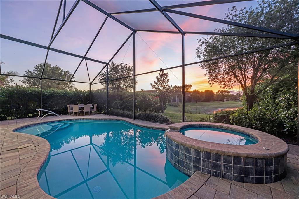 View of swimming pool with a pool with connected hot tub, a lanai, a patio area, and a sunroom