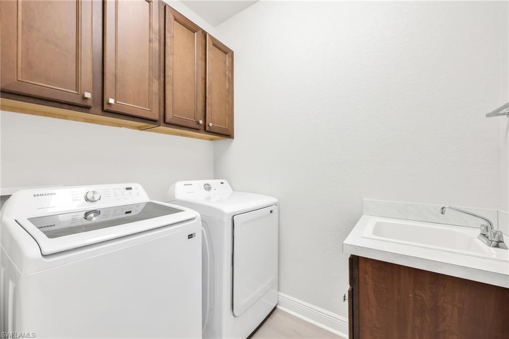 Washroom with cabinet space and washing machine and clothes dryer