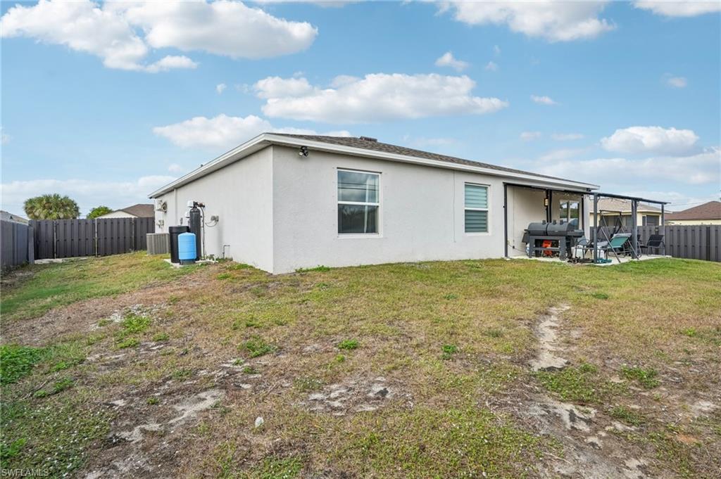 Back of house with a fenced backyard, a patio area, and stucco siding
