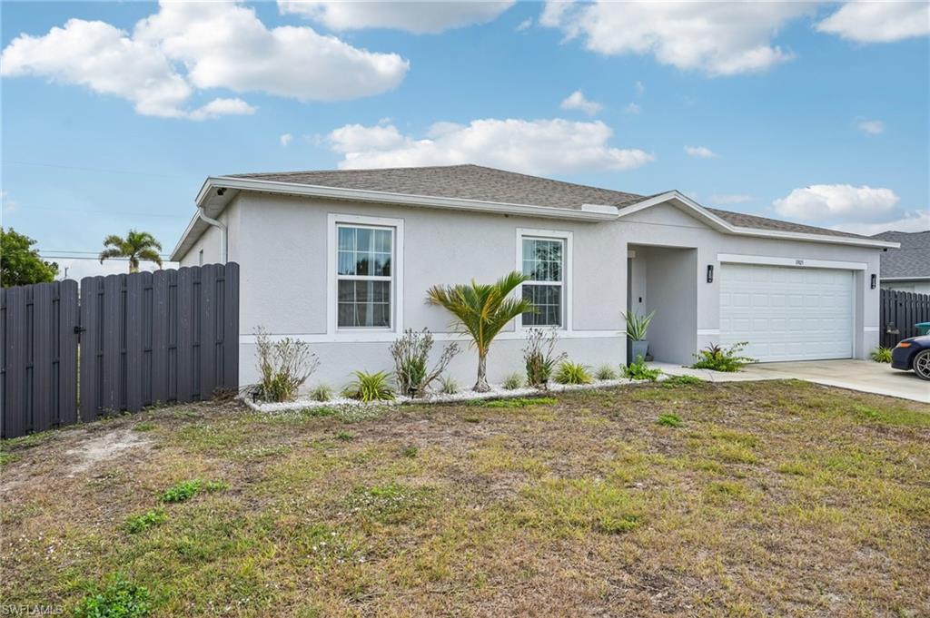 Single story home with stucco siding, roof with shingles, a garage, and concrete driveway