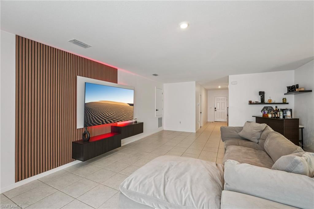 Living area with light tile patterned flooring and recessed lighting