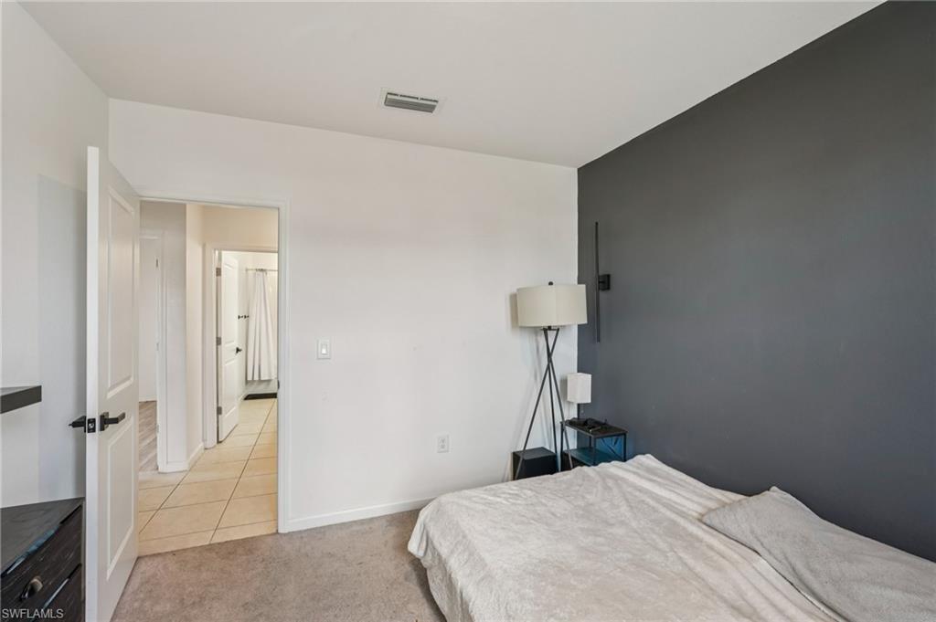 Bedroom with light colored carpet and baseboards