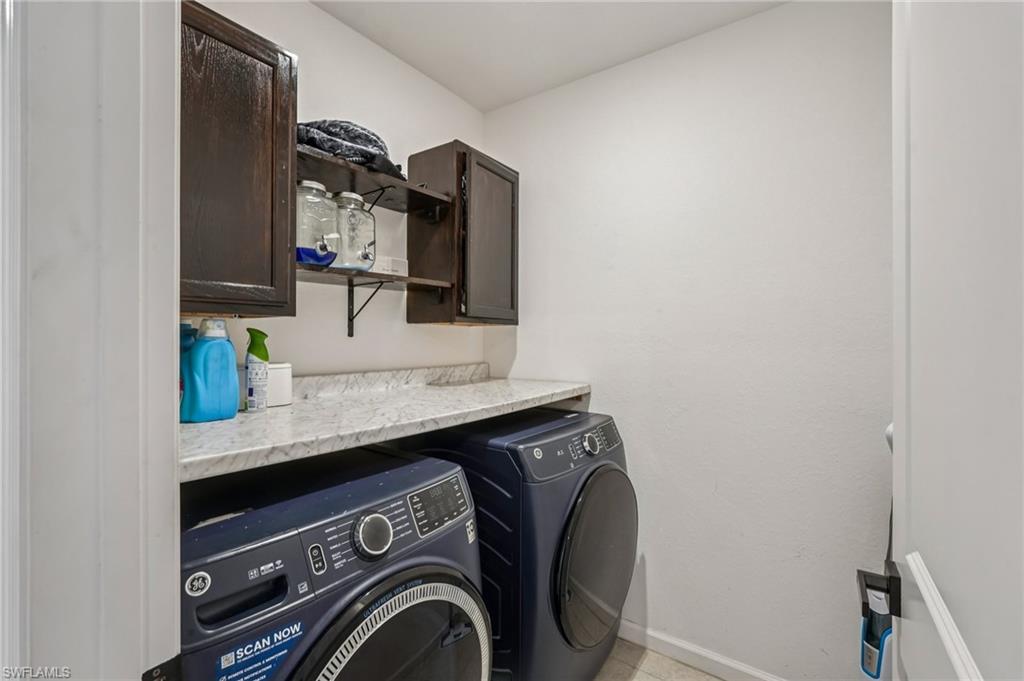 Washroom featuring cabinet space and washing machine and dryer