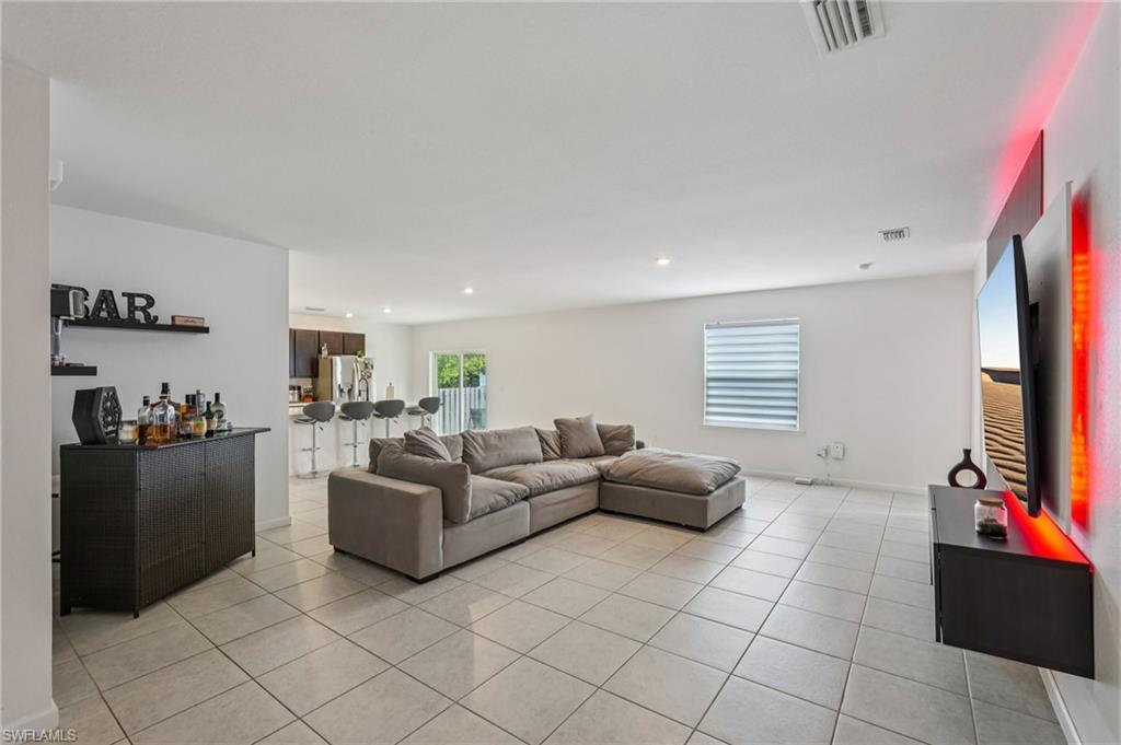 Living room with light tile patterned floors and recessed lighting