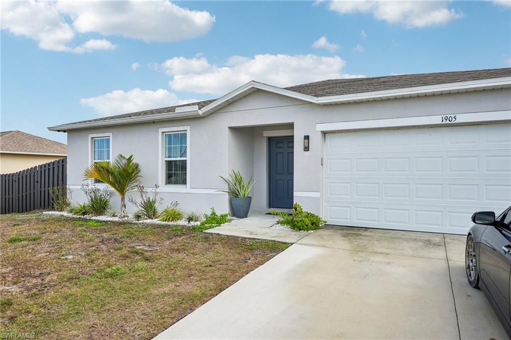 Single story home with stucco siding, driveway, and a garage