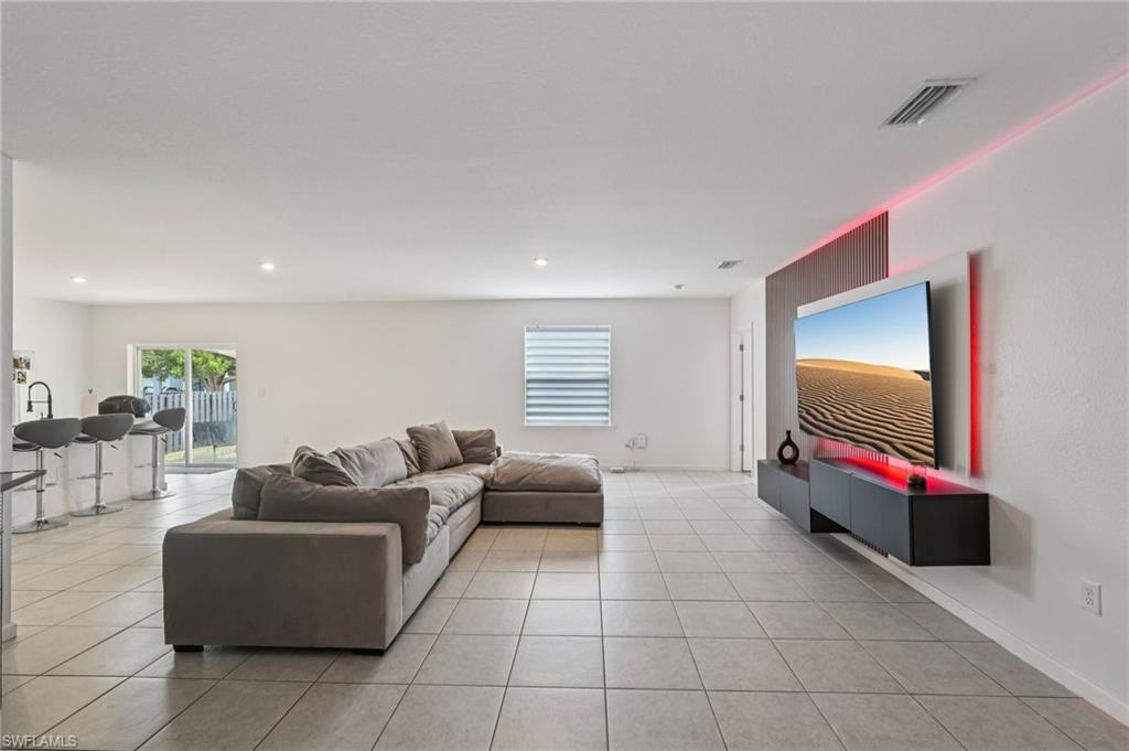 Living room with plenty of natural light, light tile patterned floors, and recessed lighting