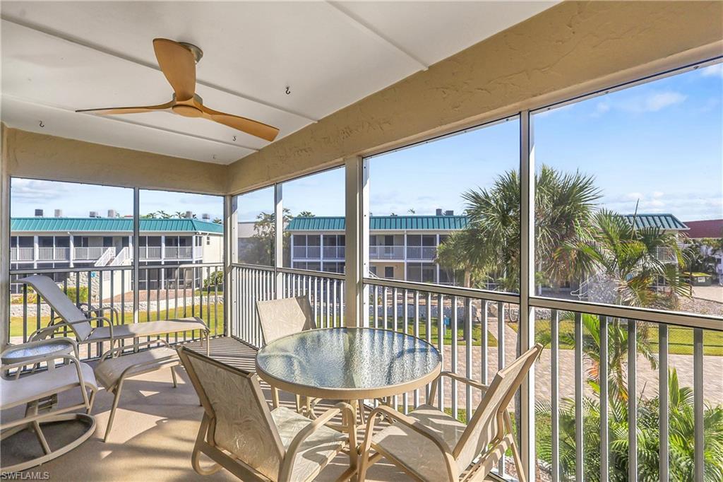 A large screened-in balcony by the beach, where salty breezes drift through the mesh and waves whisper just beyond the railings.