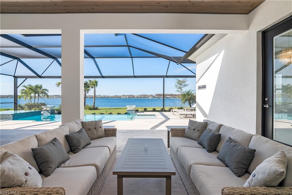 View of patio / terrace featuring an infinity pool, a sunroom, a water view, and glass enclosure