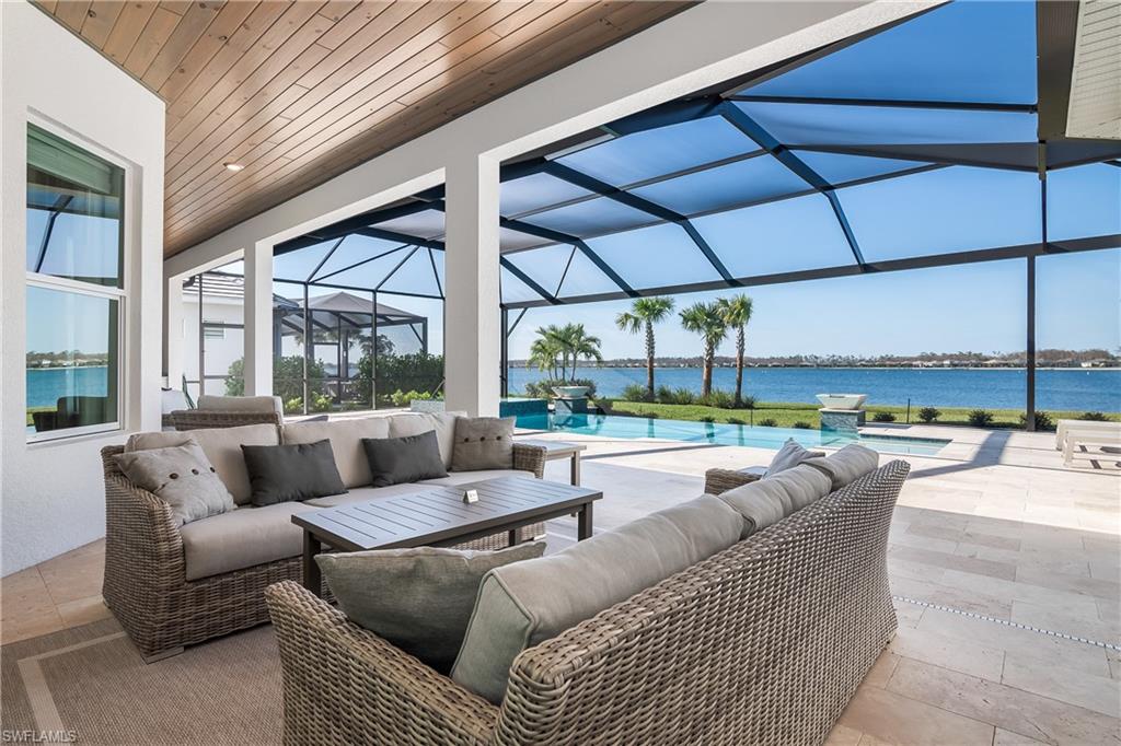 View of patio featuring a sunroom, glass enclosure, a water view, an outdoor hangout area, and an outdoor pool