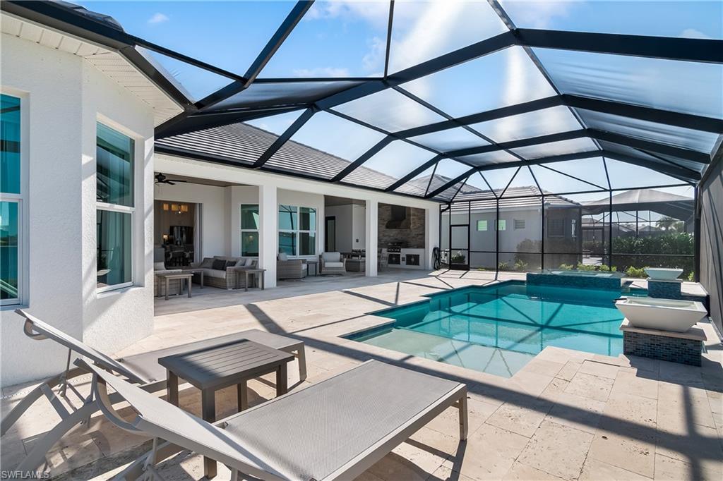 View of pool with an outdoor living space, a sunroom, a lanai, a patio area, and a pool with connected hot tub