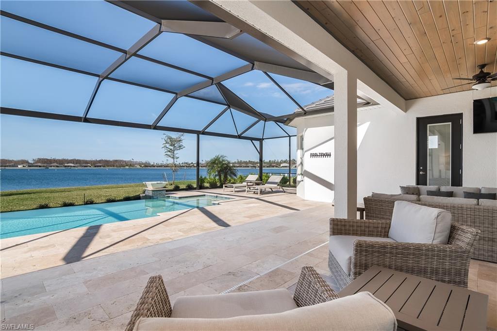 View of pool featuring a patio area, glass enclosure, a sunroom, and an outdoor living space
