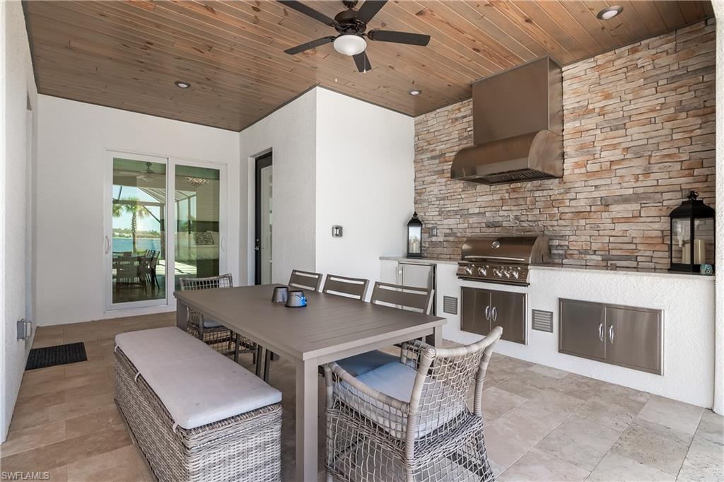 View of patio with an outdoor kitchen, ceiling fan, and outdoor dining space