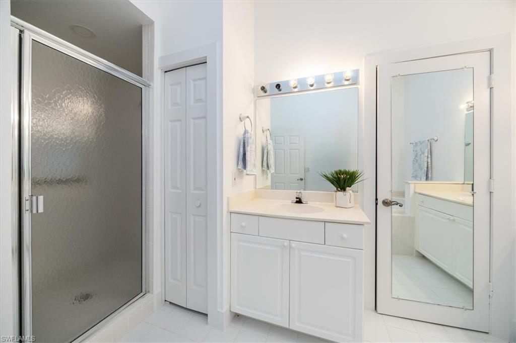 Bathroom featuring vanity, tile patterned floors, and a shower with shower door