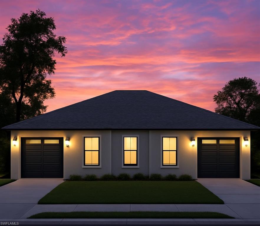 View of front of house featuring roof with shingles, a lawn, concrete driveway, and stucco siding