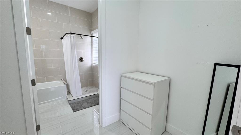 Bathroom featuring a stall shower and a tub