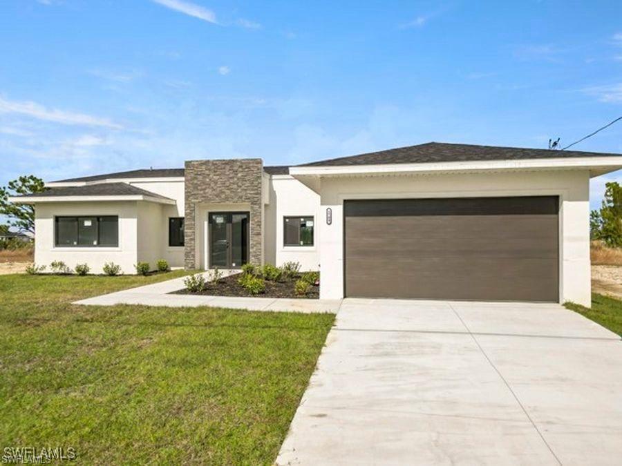 View of front facade featuring stone siding, stucco siding, driveway, and a front lawn
