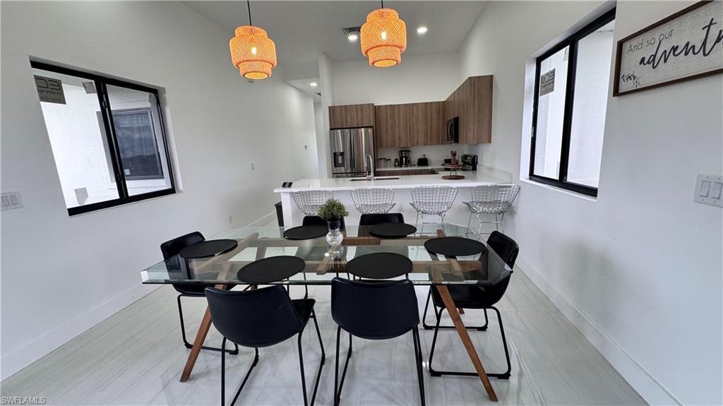 Dining area with recessed lighting, light wood-type flooring, and a high ceiling