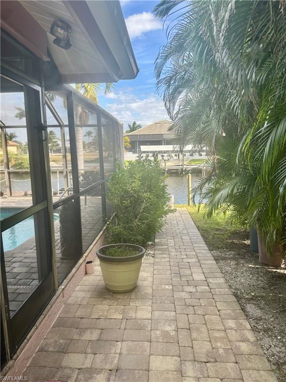 View of patio / terrace with a lanai, a sunroom, and a water view