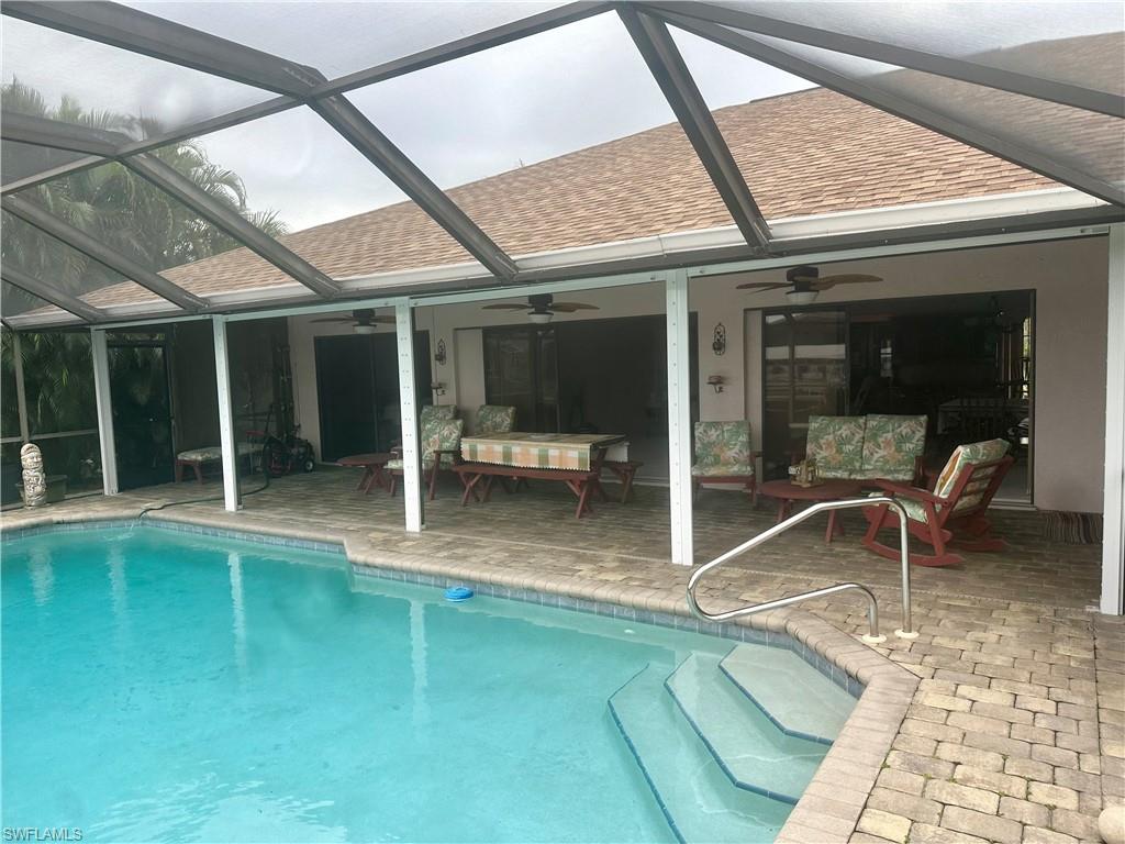 Swimming pool featuring glass enclosure, a sunroom, and a patio area