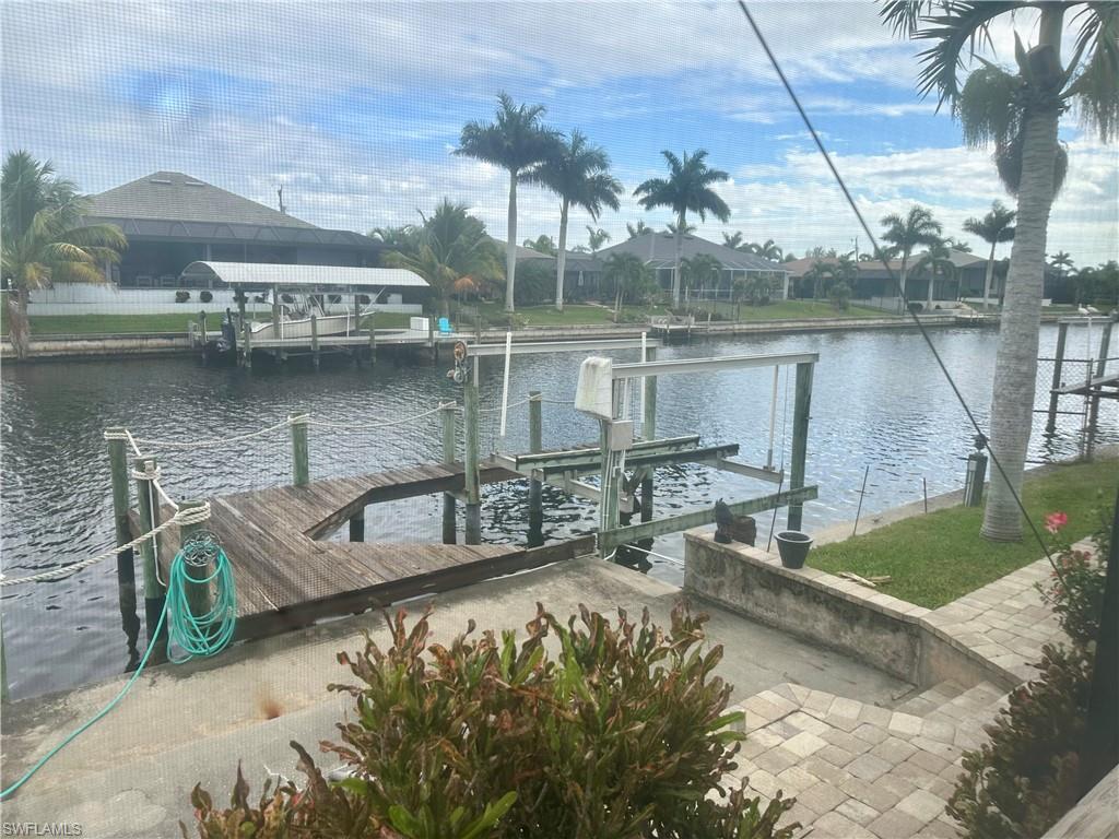 Dock area featuring boat lift and a water view
