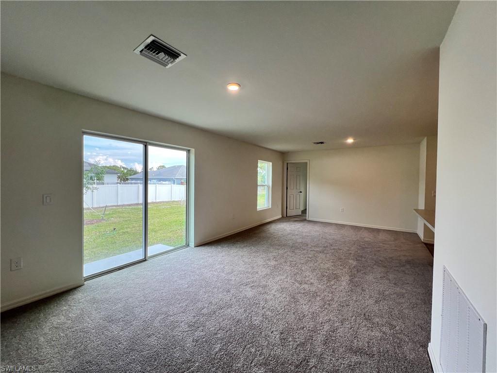 Carpeted empty room with recessed lighting