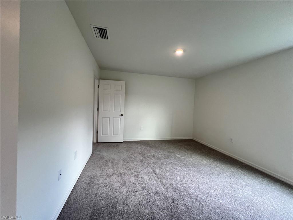 Spare room with carpet and baseboards