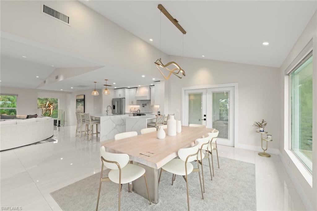 Dining room featuring french doors, vaulted ceiling, recessed lighting, and light tile patterned flooring