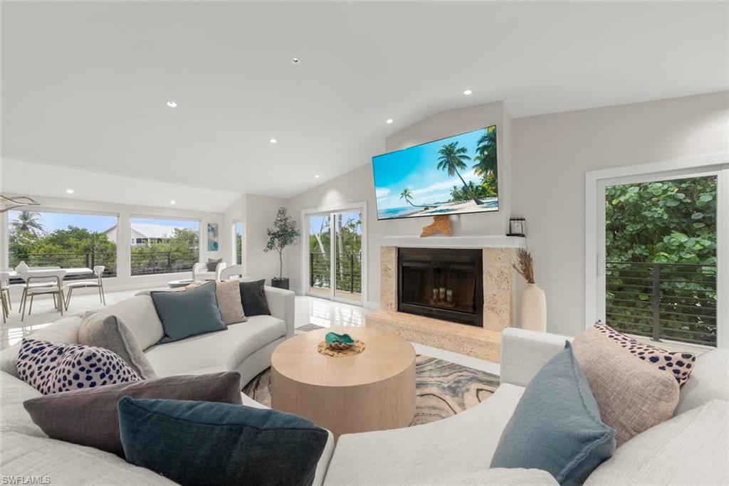 Living area with recessed lighting, a premium fireplace, and lofted ceiling