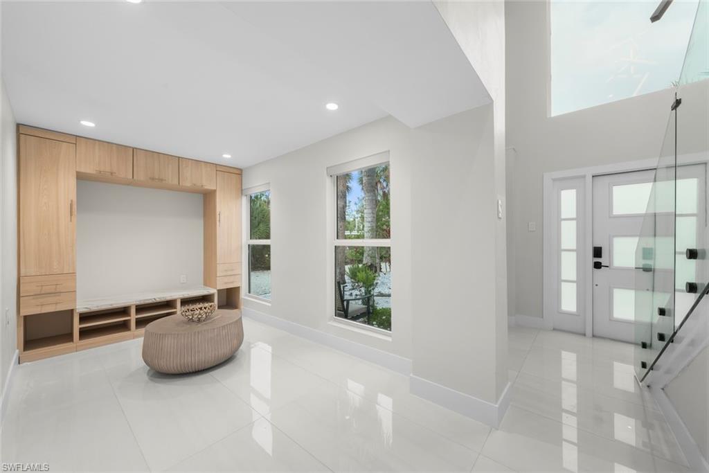 Foyer entrance with light tile patterned flooring and recessed lighting