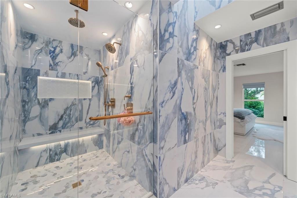 Ensuite bathroom with recessed lighting, a marble finish shower, and marble tiled floors