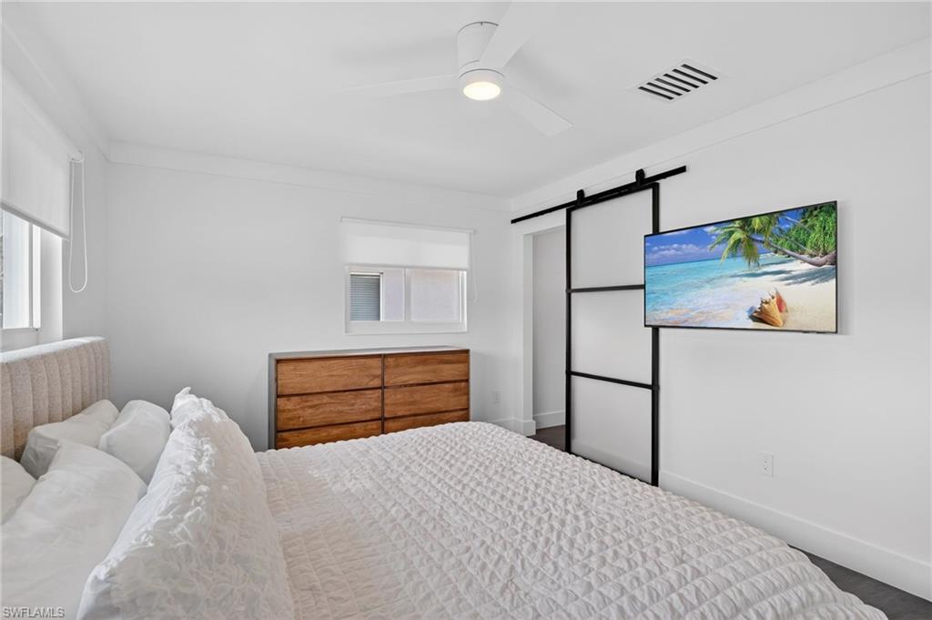 Bedroom featuring a barn door and a ceiling fan