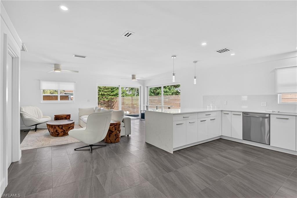 Kitchen featuring white cabinetry, decorative light fixtures, a peninsula, dishwasher, and recessed lighting