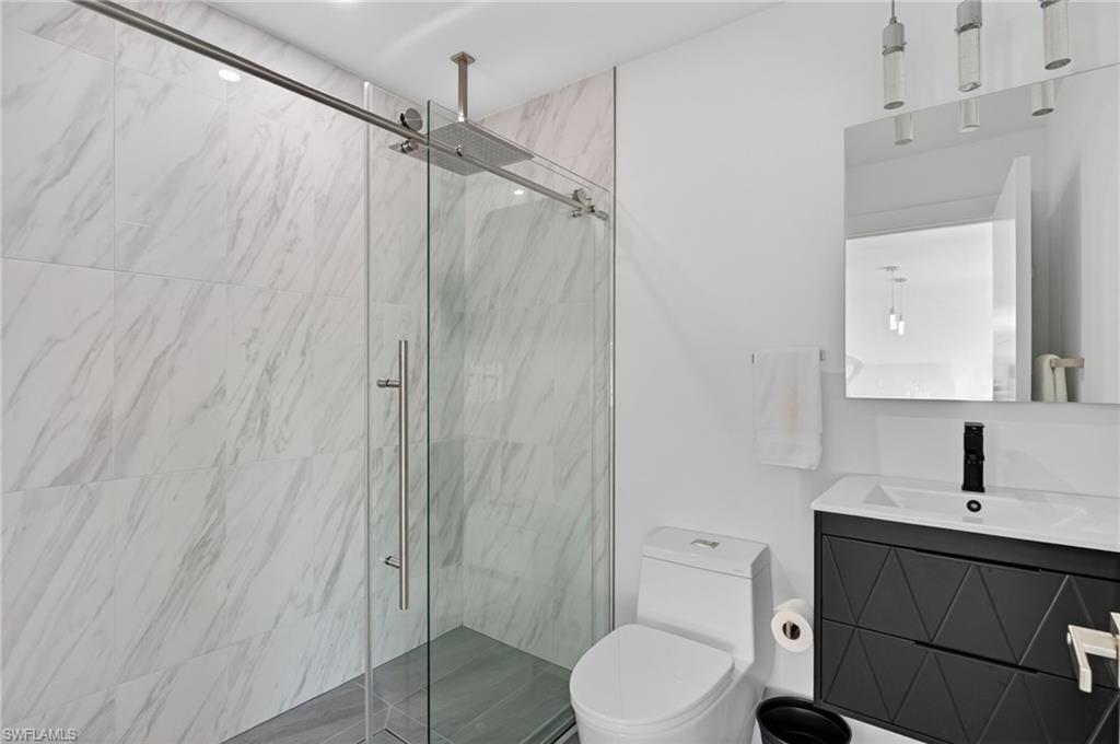 Bathroom with a marble finish shower and vanity