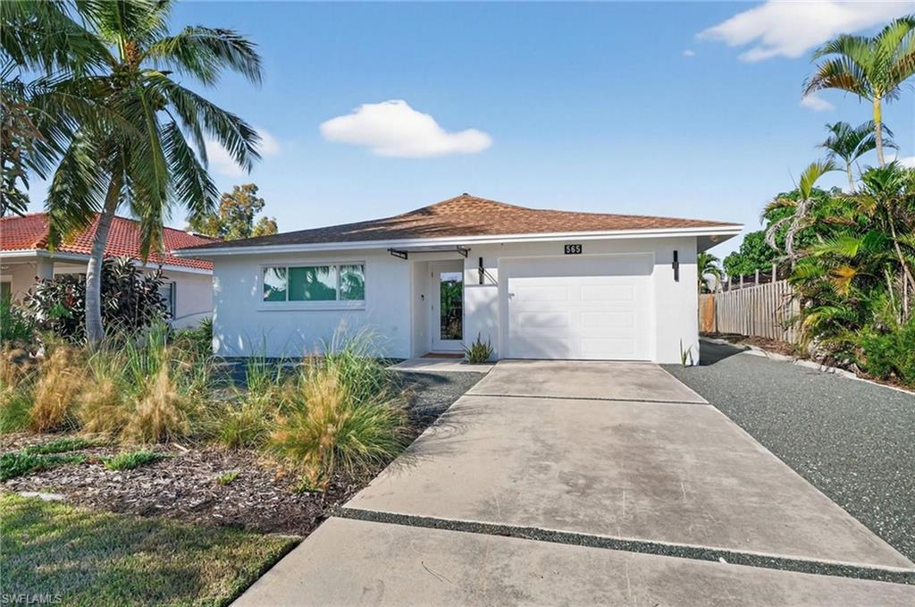 View of front of house with stucco siding, concrete driveway, and a garage