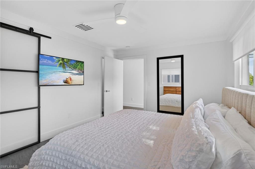 Bedroom with a barn door and ceiling fan