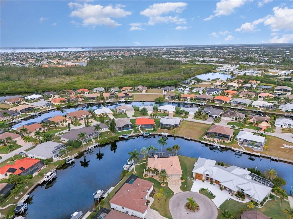 Aerial view of property's location featuring a nearby body of water and nearby suburban area