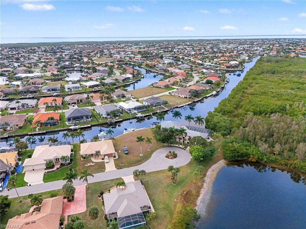 Aerial view of property and surrounding area featuring a large body of water and nearby suburban area