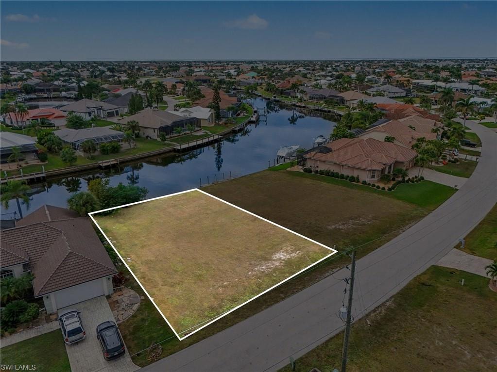 Aerial view of residential area featuring property parcel outlined and a nearby body of water