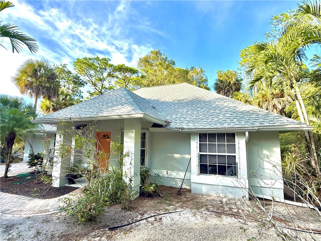 View of front of property with roof with shingles and stucco siding