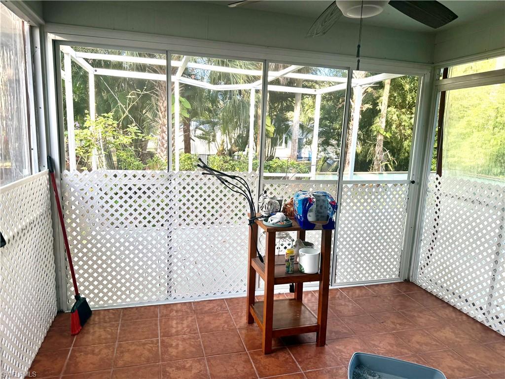Unfurnished sunroom featuring healthy amount of natural light and ceiling fan
