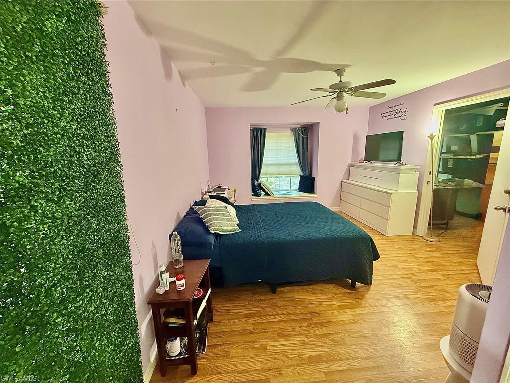 Bedroom with a ceiling fan and light wood-style floors