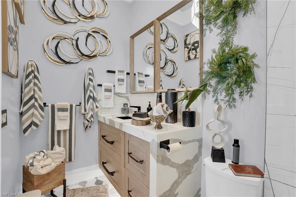 Bathroom featuring vanity, decorative backsplash, and ornamental molding - Virtually Edited Image