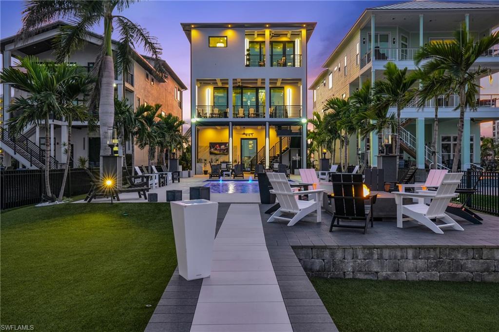 Back of house featuring a patio area, stairs, an outdoor fire pit, and a wooden deck - Virtually Edited Image